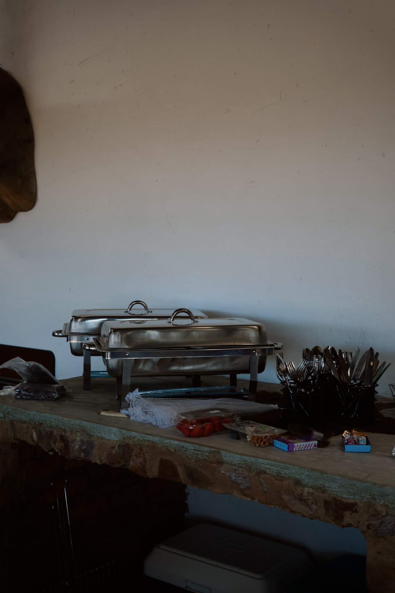 Buffet chafing dishes and cutlery on the stone counter