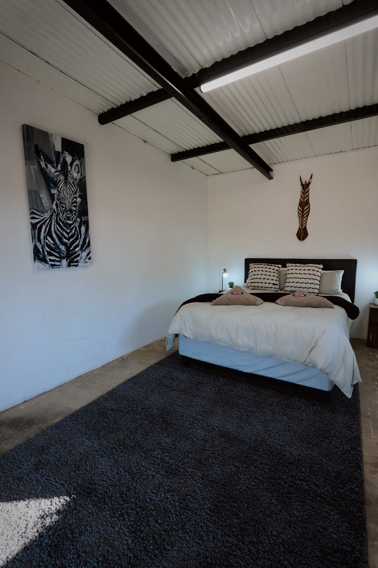 Double room with zebra artwork and soft rug