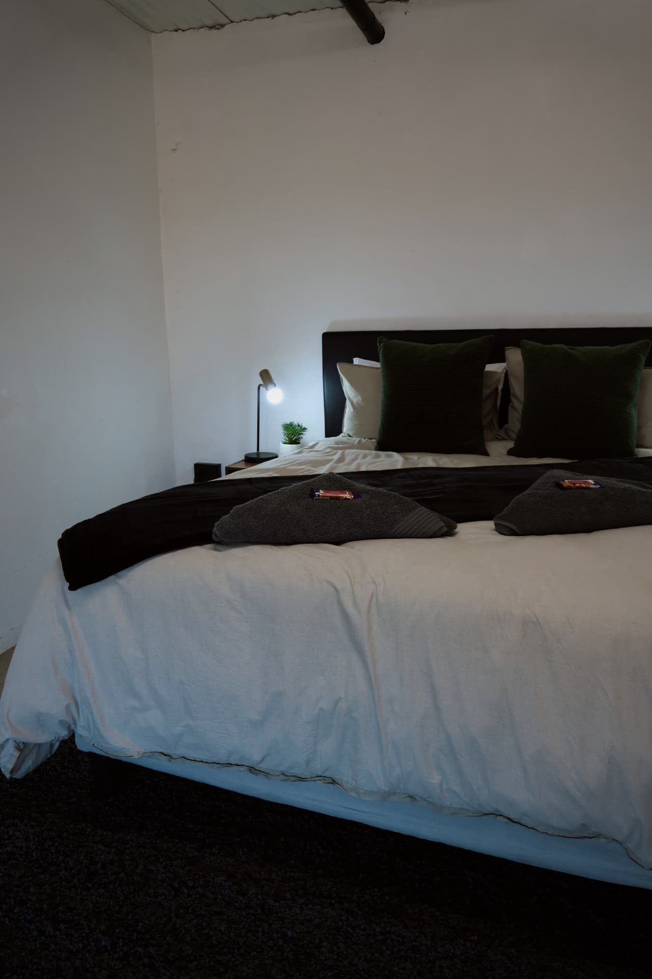 Bed turned down with welcome treats on the towels