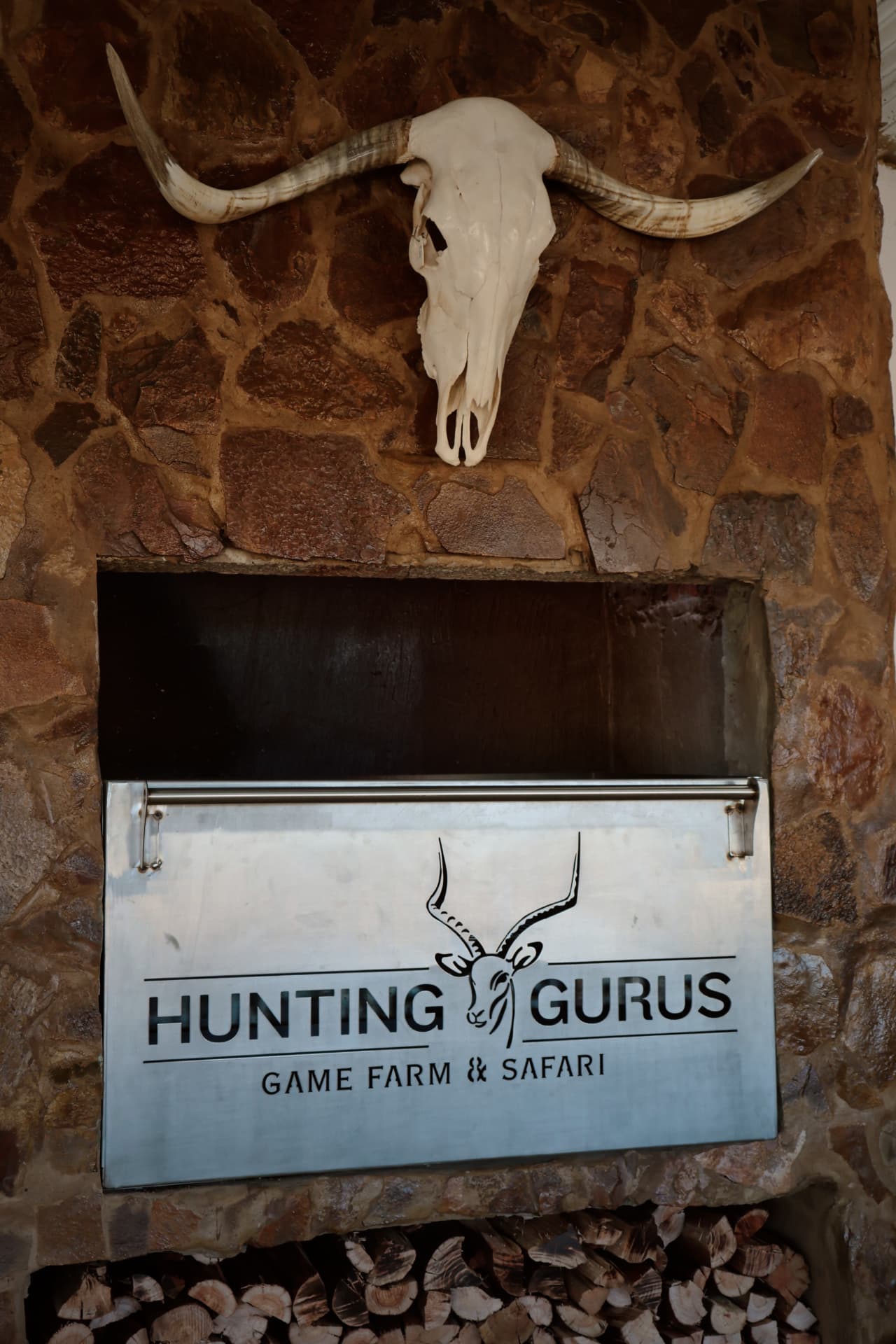 Stone braai wall with skull mount and farm sign