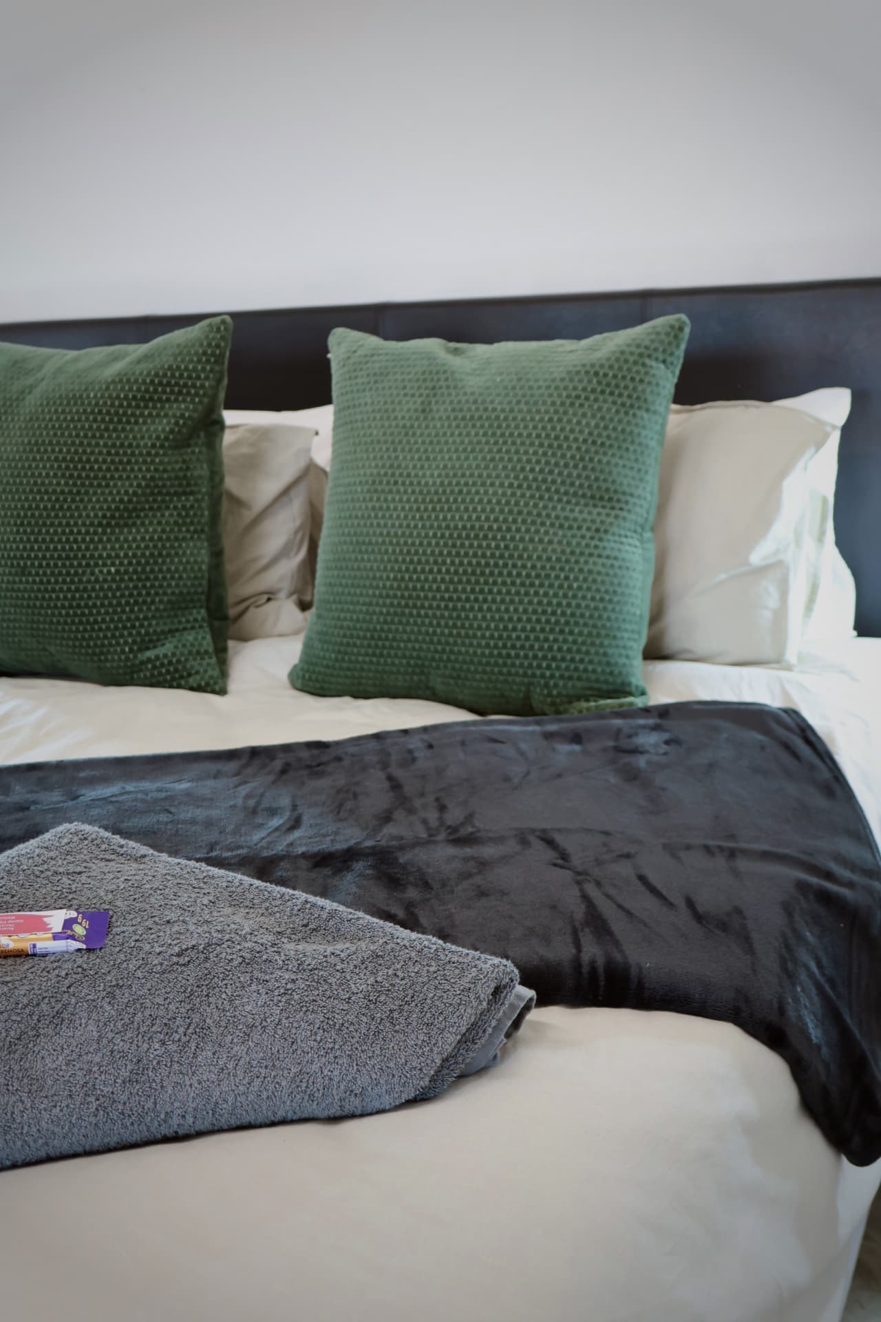 Fresh linen, green scatter cushions and towels