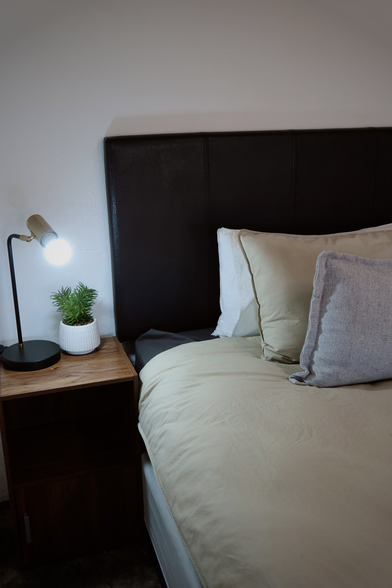 Bedside detail with reading lamp and fresh linen