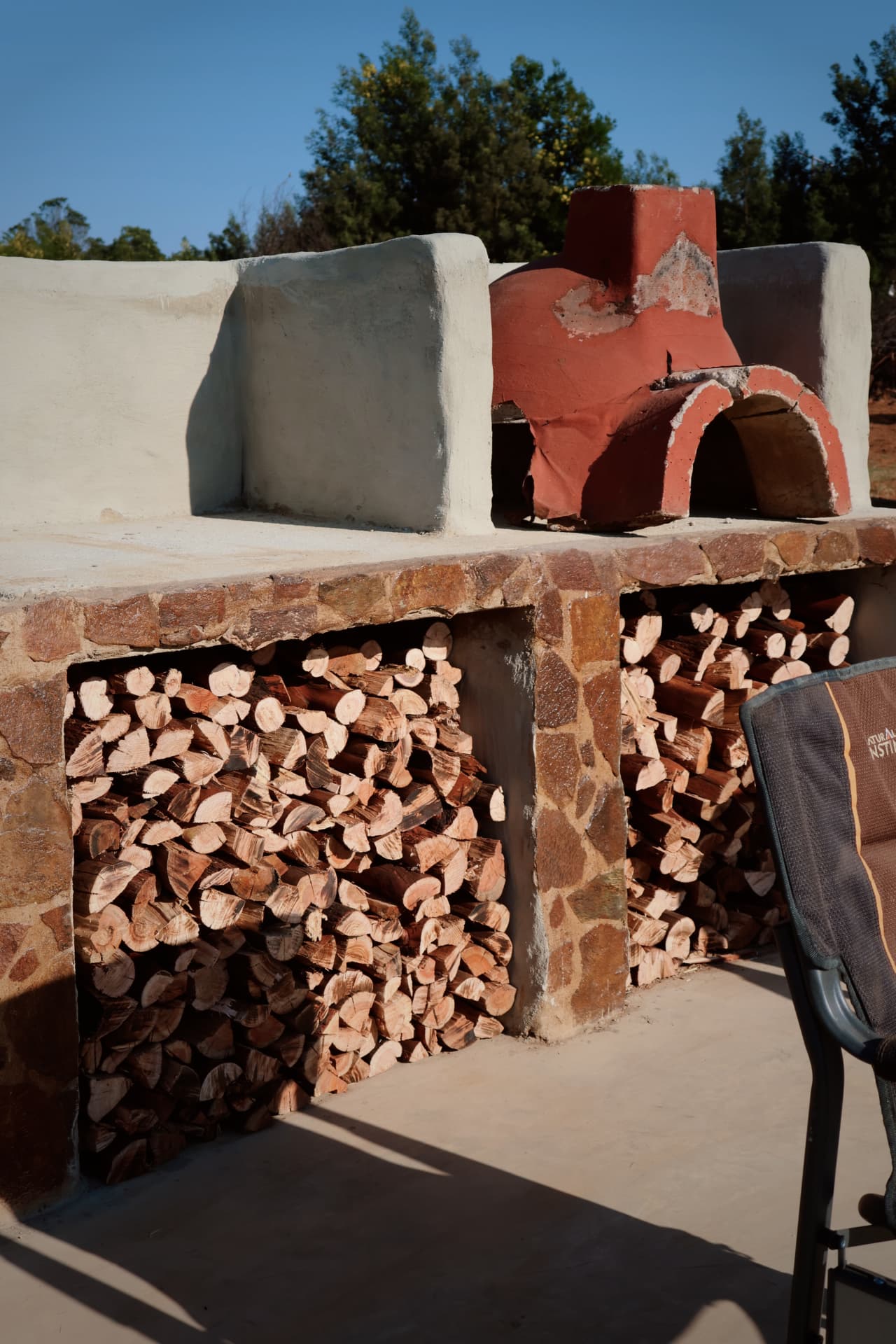 Outdoor pizza oven and stacked firewood